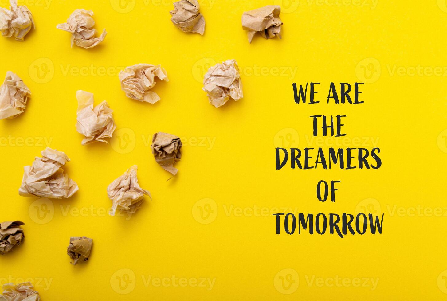 Yellow background with paper on it We are the dreamers of tomorrow photo