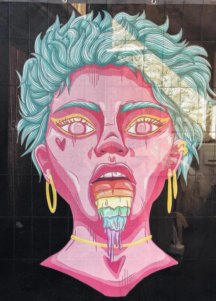 Cologne, Germany - April 9, 2022 - Woman with a rainbow colored tongue is depicted in a colorful photo