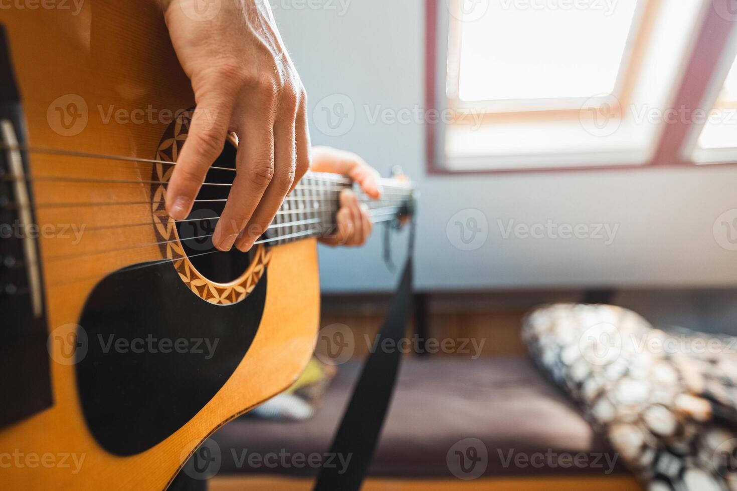 Perspective of an acoustic guitar being played, with fingers pressing the fretboard, capturing the warmth of natural wood, the resonance of the strings. Indoor music photo