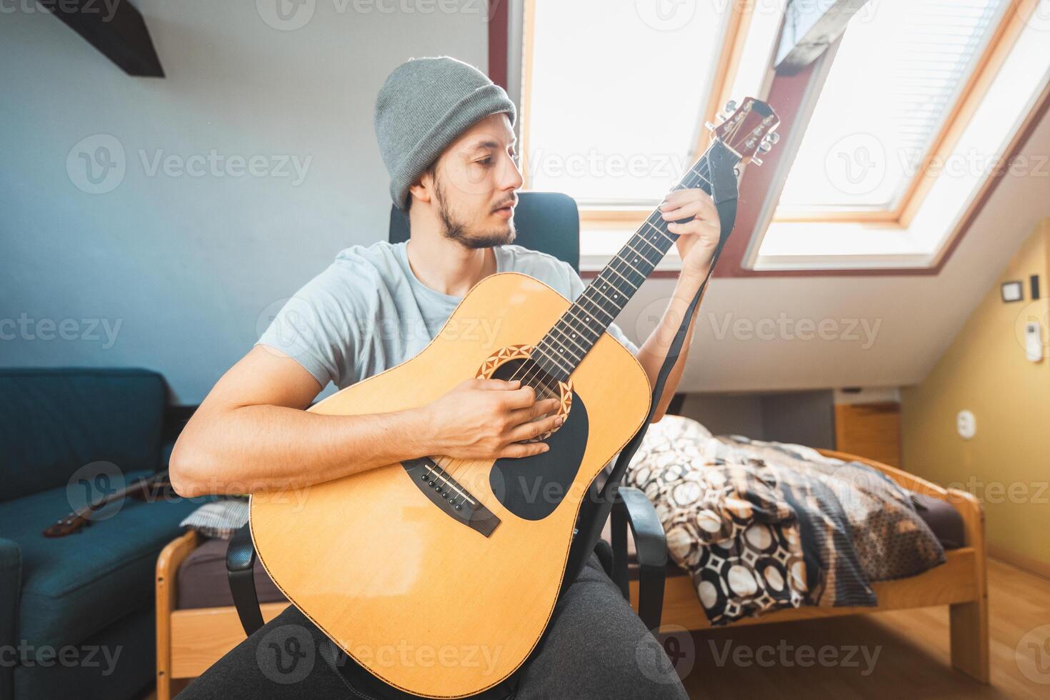 Young man leans back while practicing chords photo