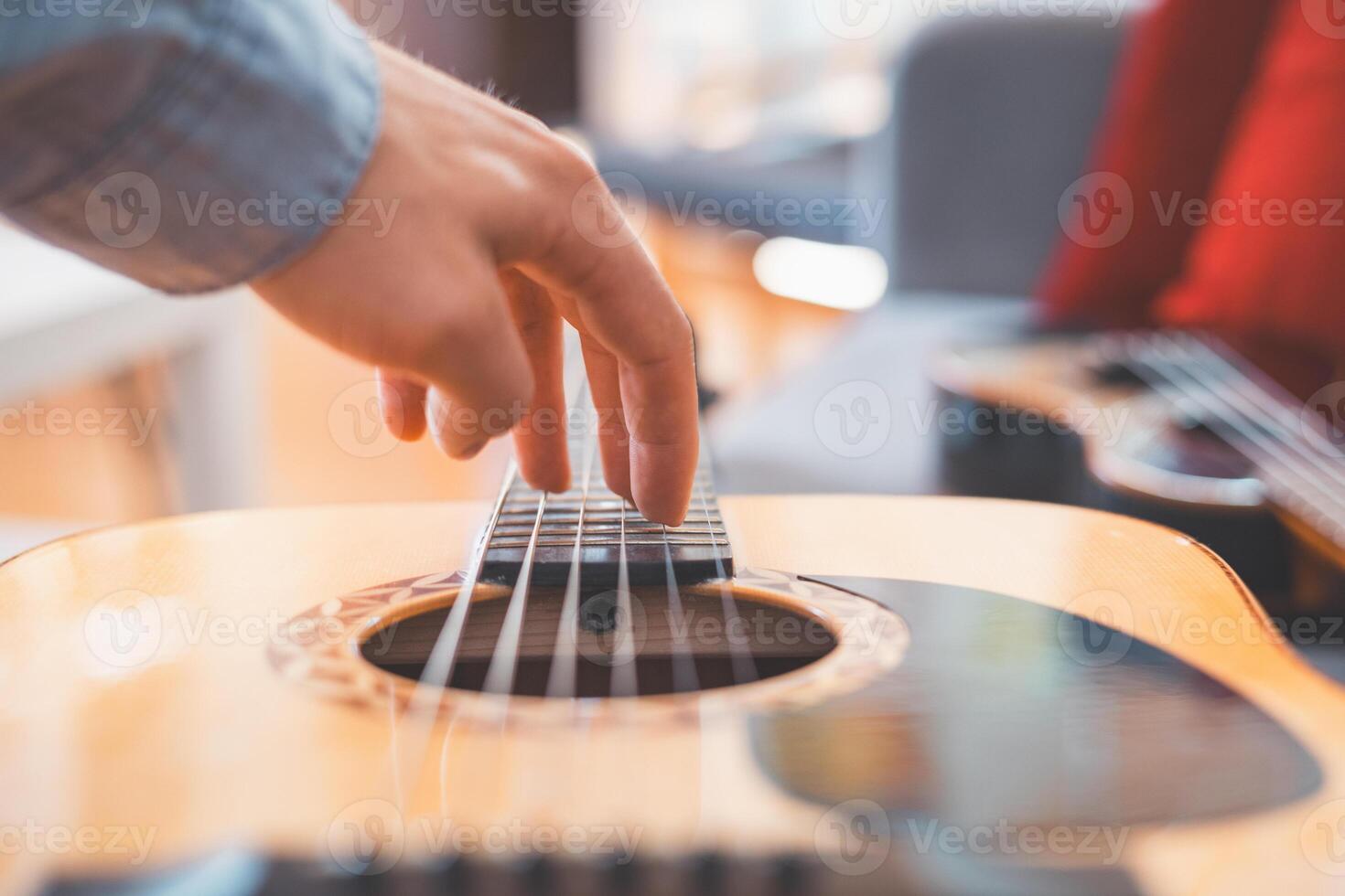 Chords flow as man practices guitar alone indoors photo