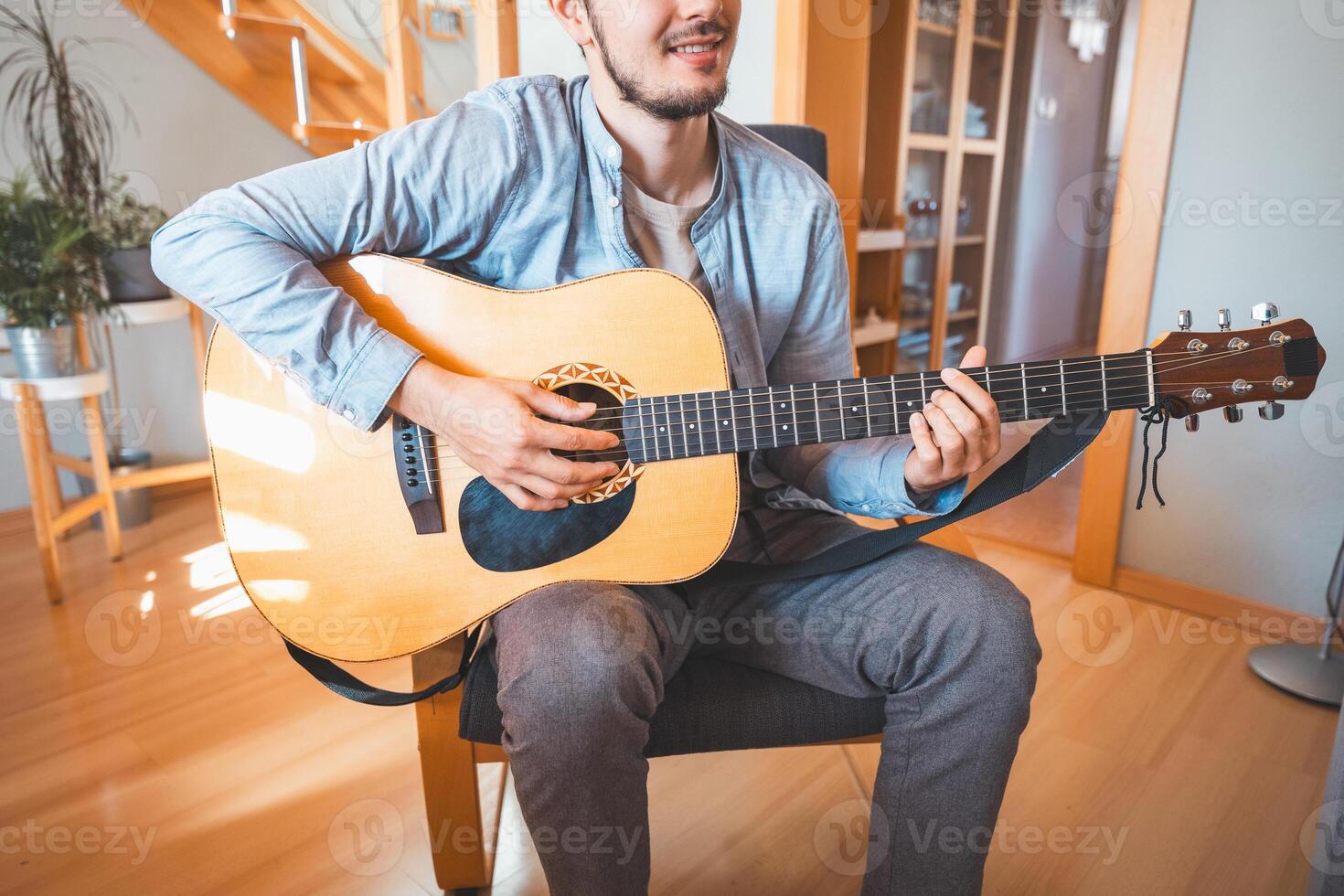 Playing a beautiful wooden acoustic guitar and composing new songs. Immersed in the sweet tones of the guitar. Music that heals the soul photo
