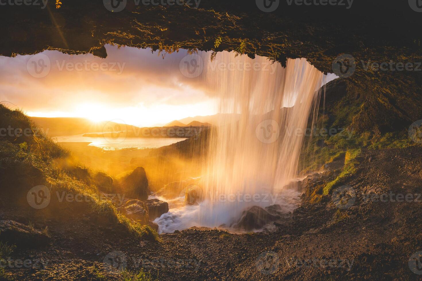 Selvallafoss waterfall on the Snaefellsnes Peninsula in Iceland, captured from behind as cold, clear water cascades in front of a magical sunset photo