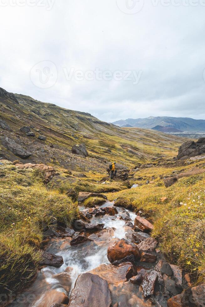 Rust colored waterfall flows through volcanic rocks in Iceland wild highlands, where fire meets water in a surreal, untouched natural symphony photo
