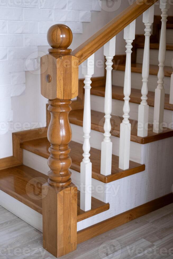 A wooden staircase, with a railing will lead to the top photo