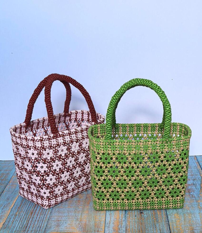 Two woven bags with different colors on a wooden table photo