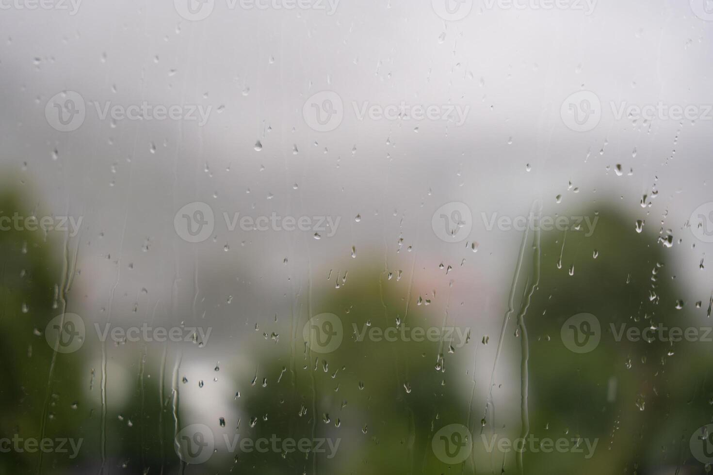 Raindrops on window with blurred view of trees and overcast sky in Bergen, Norway. photo