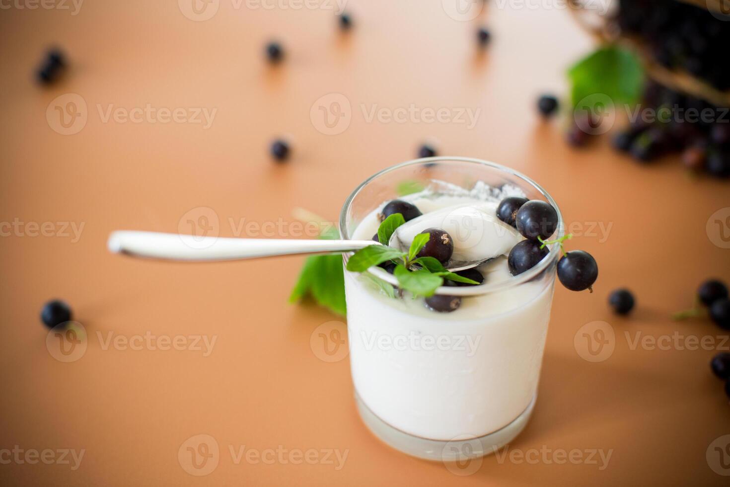 Healthy fermented milk product with berries and spoon on brown background photo