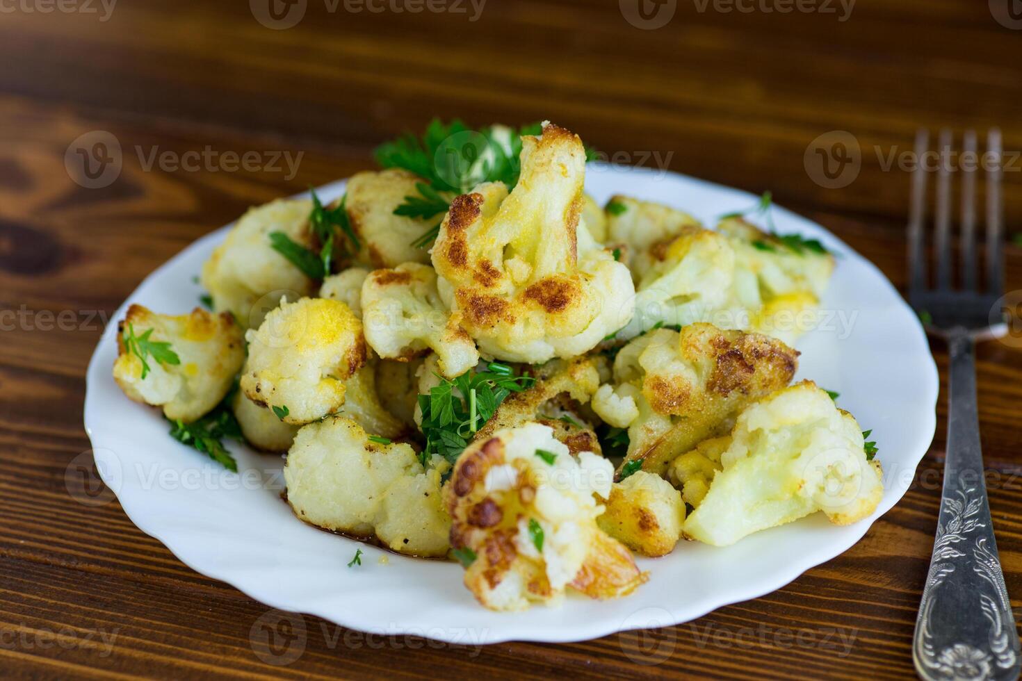 Fried cauliflower with spices and herbs in a frying pan . photo
