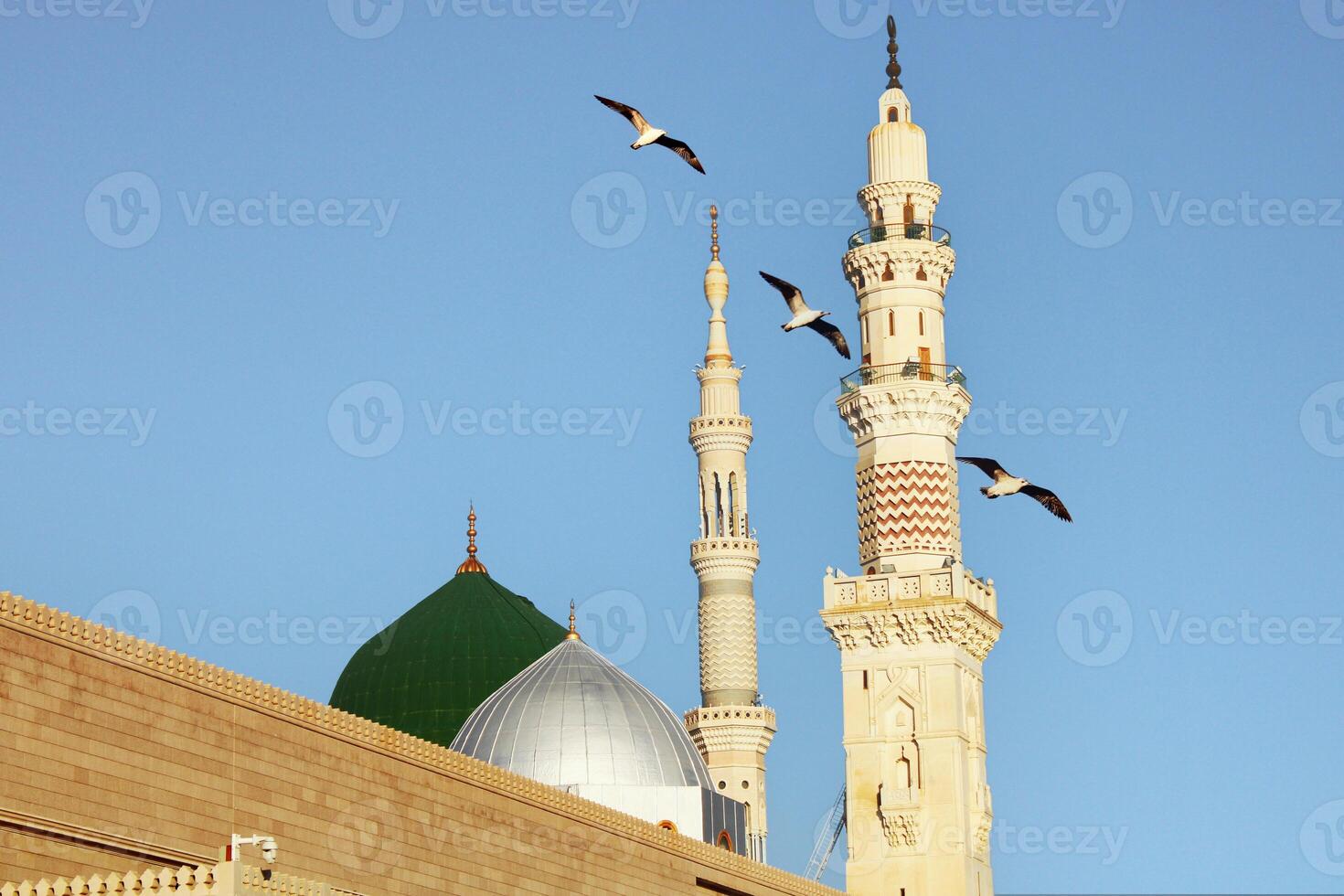 Masjid nabi of Medina. Green dome. birds flying in the air photo