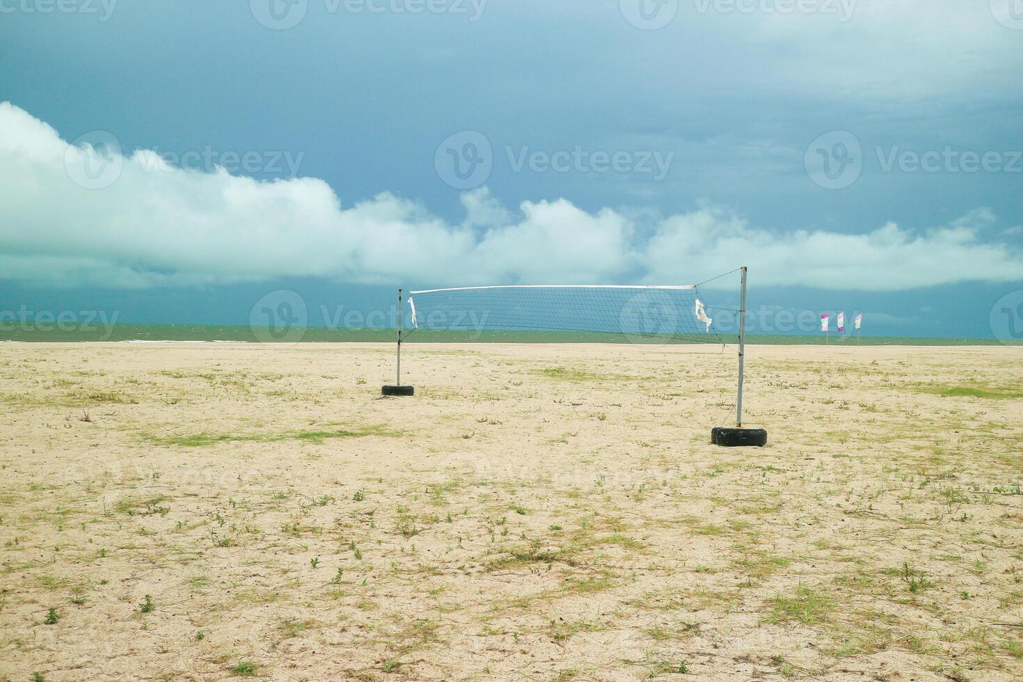 Tranquil view of an empty beach volleyball court near the sea. Bright blue sky and soft clouds frame the serene tropical coastal scene of Southeast Asia. photo