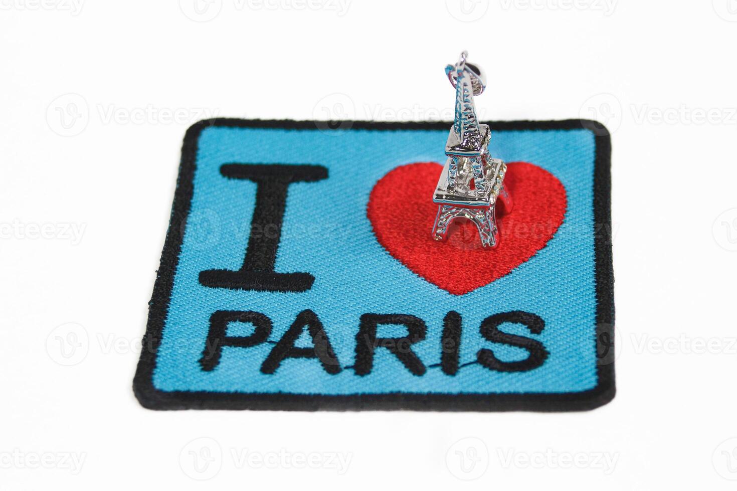 Embroidered message I LOVE PARIS with a red heart and small Eiffel Tower placed on top. Isolated on white, perfect for romantic travel and Paris themes. photo