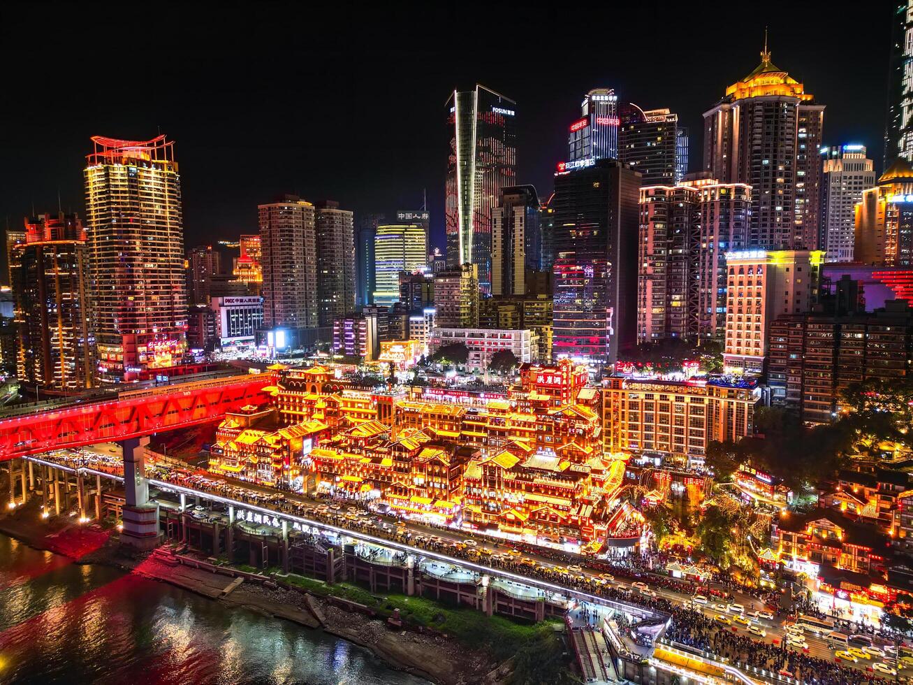 Chongqing, China - APR 02, 2025-Aerial Night view Cityscape of the famous downtown shopping complex Hongyadong with illuminated bridge and highrise building. photo