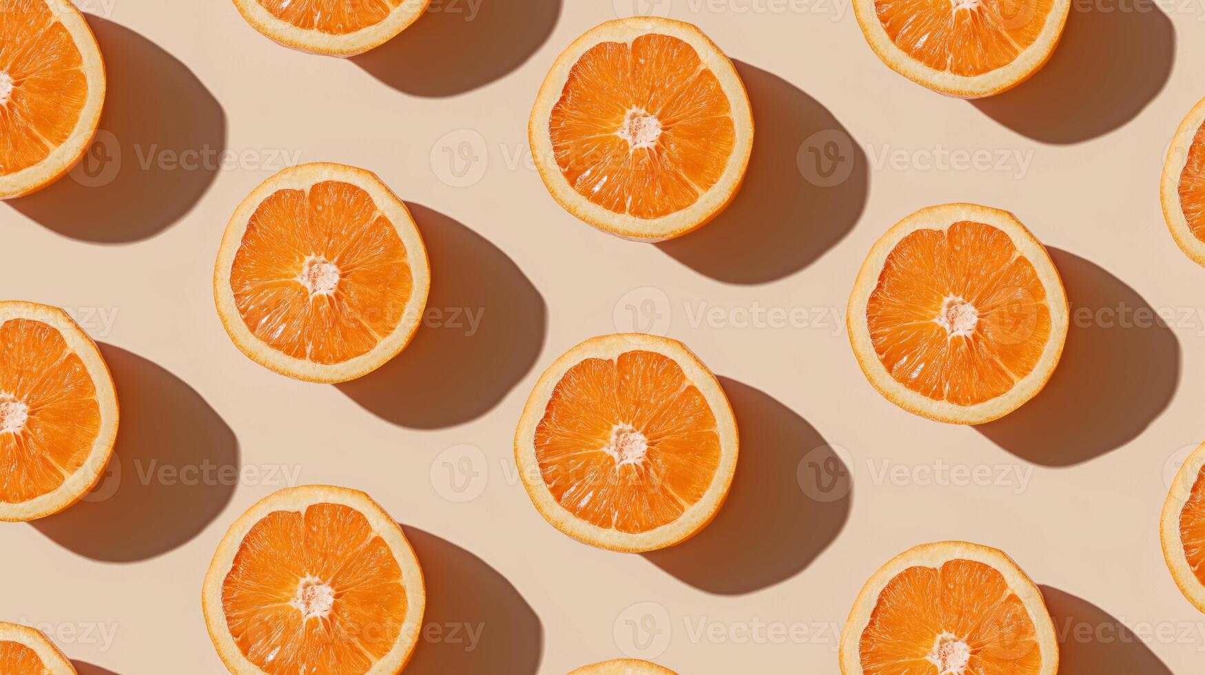 Orange slices are neatly positioned in a grid on a beige surface, showcasing their vibrant color. photo