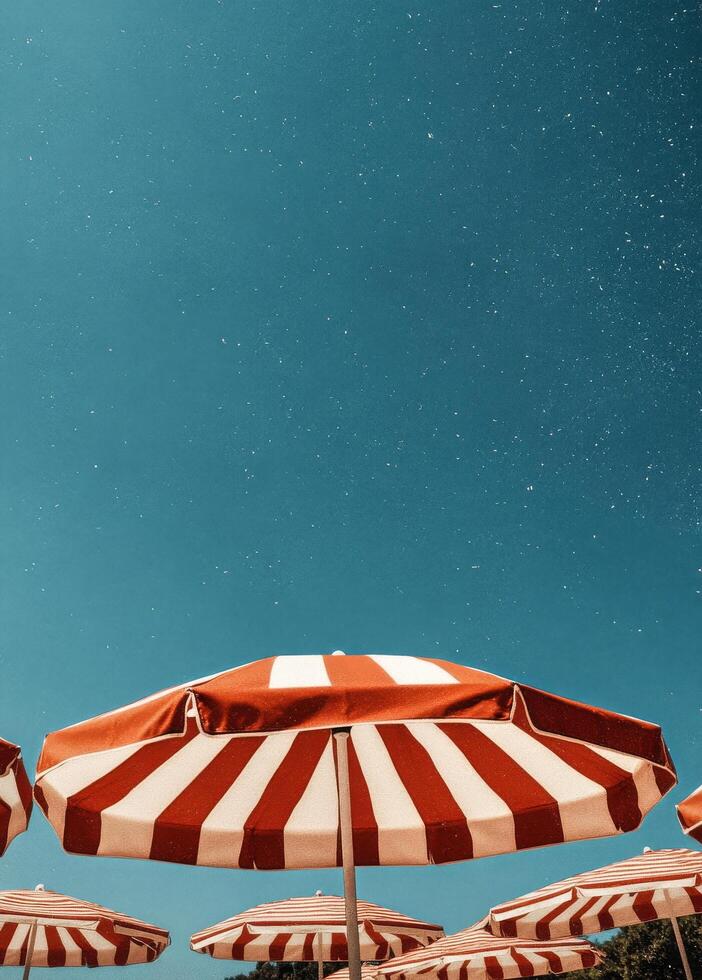 Bright Summer Afternoon With Striped Umbrellas Under Clear Blue Sky photo