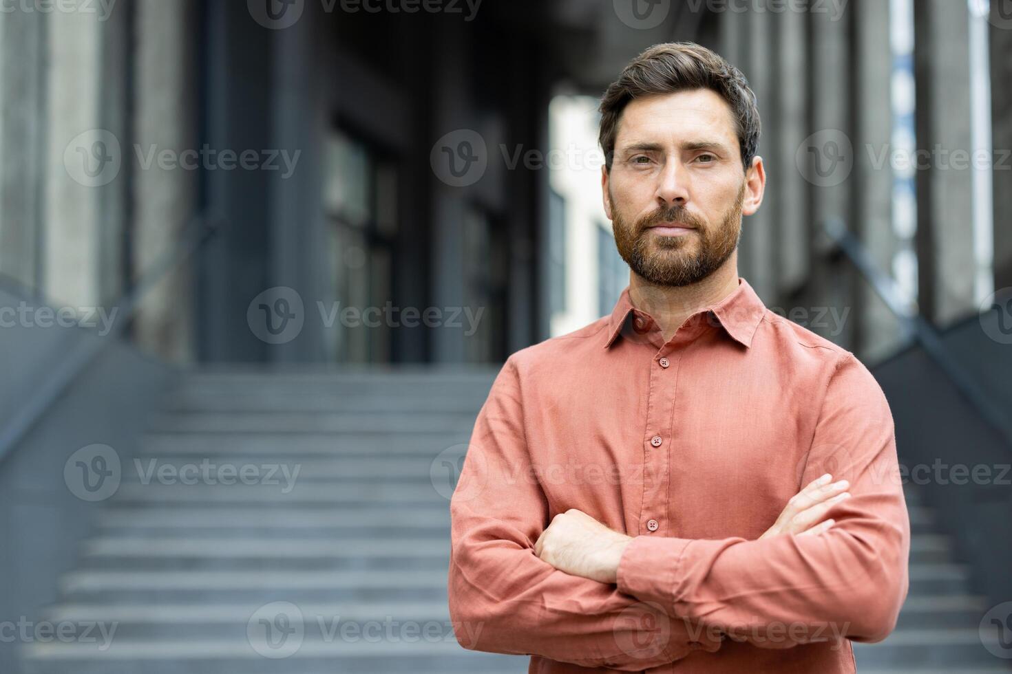 Portrait of a serious confident businessman outside an office building, man with crossed arms looking confidently at the camera photo