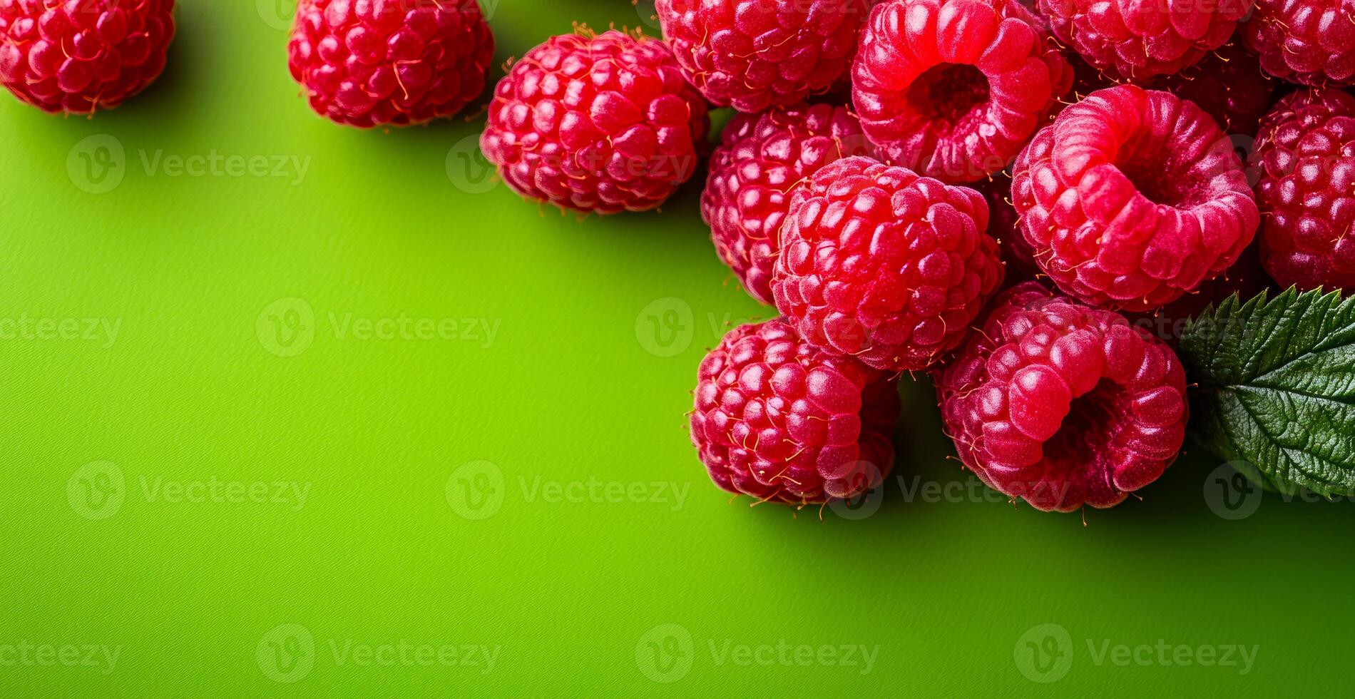 Raspberries on green backdrop. Bright red raspberries rest against a lively green surface, showcasing their juicy texture and inviting color. photo