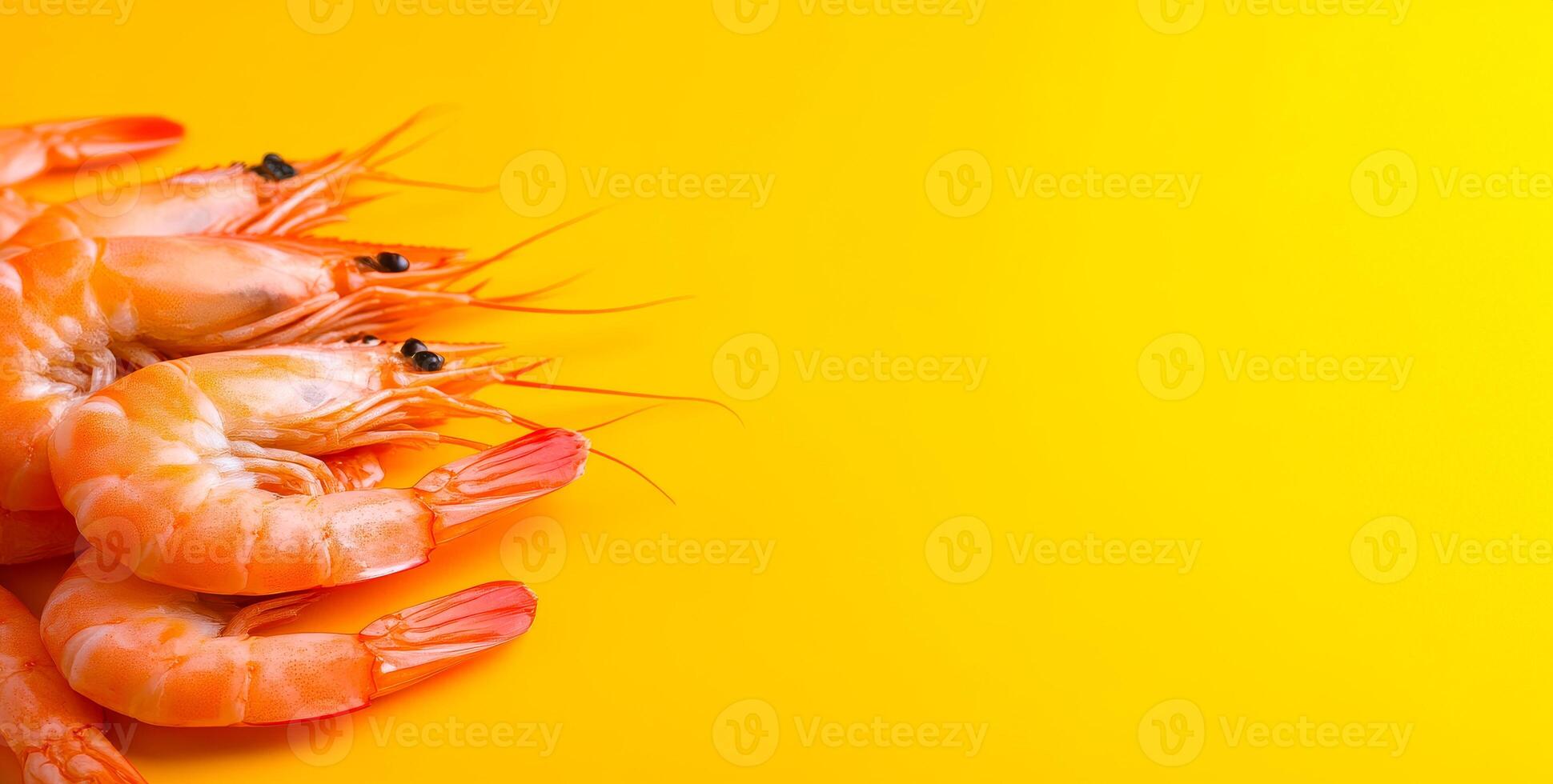 Shrimp on bright yellow backdrop. Fresh shrimp are showcased on a bright yellow surface, highlighting their orange color and unique features. photo