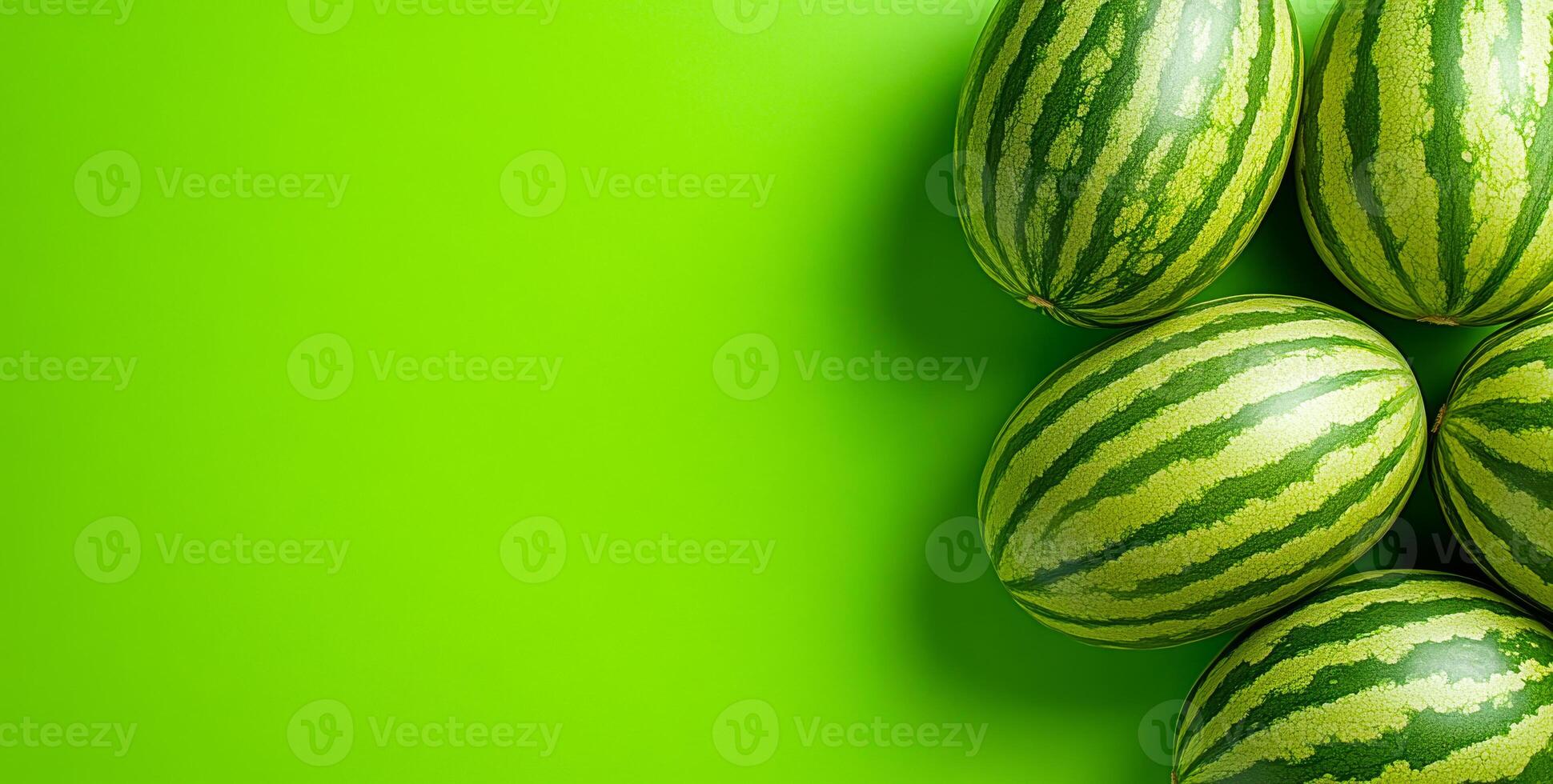 Colorful watermelons on green background. Fresh, ripe watermelons are arranged on a vibrant green backdrop, showcasing their striped skin and juicy appeal. photo