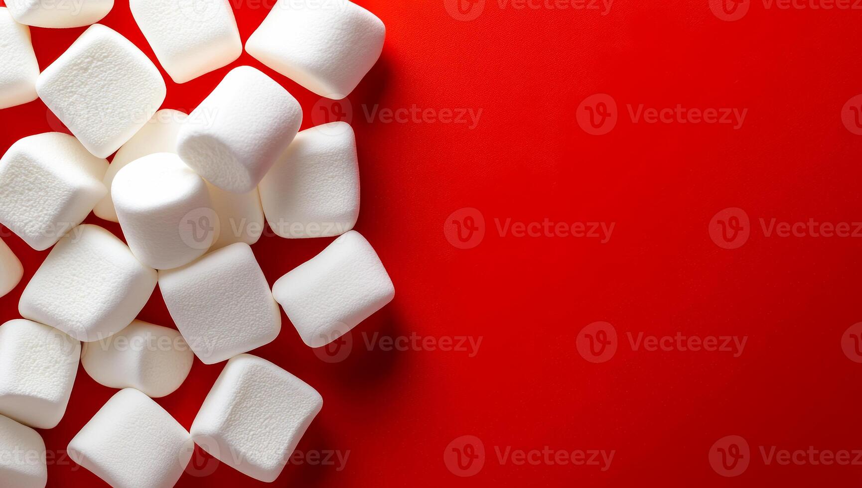 Marshmallows scattered on red background. White marshmallows are arranged haphazardly on a vibrant red surface, creating a playful contrast in colors. photo
