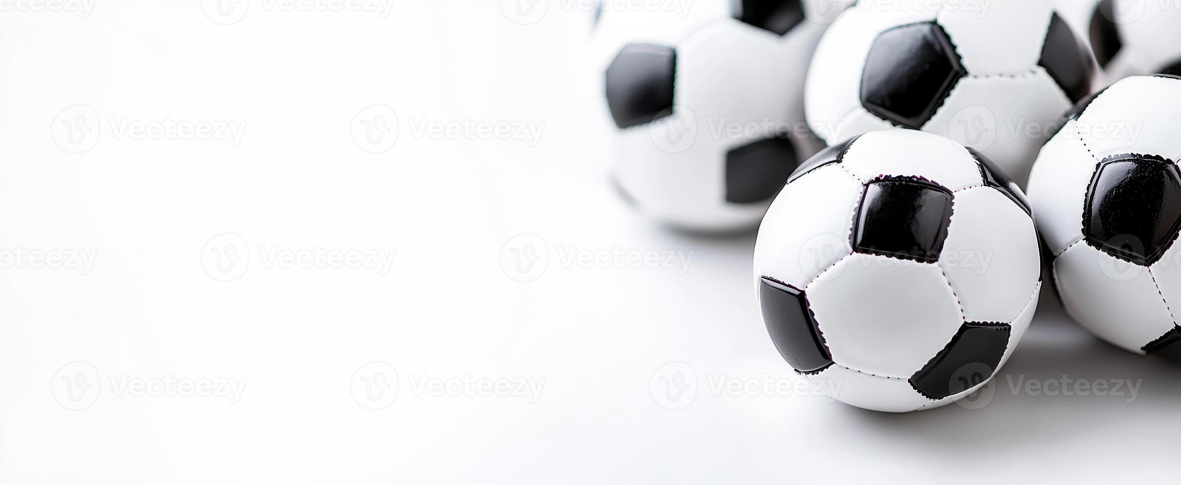 Soccer balls piled together for play. Several soccer balls with black and white panels are stacked close together, ready for a game or practice session. photo