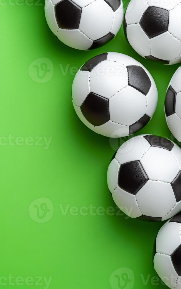 Soccer balls on green backdrop. Several black and white soccer balls are grouped together on a vibrant green surface in this playful display. photo