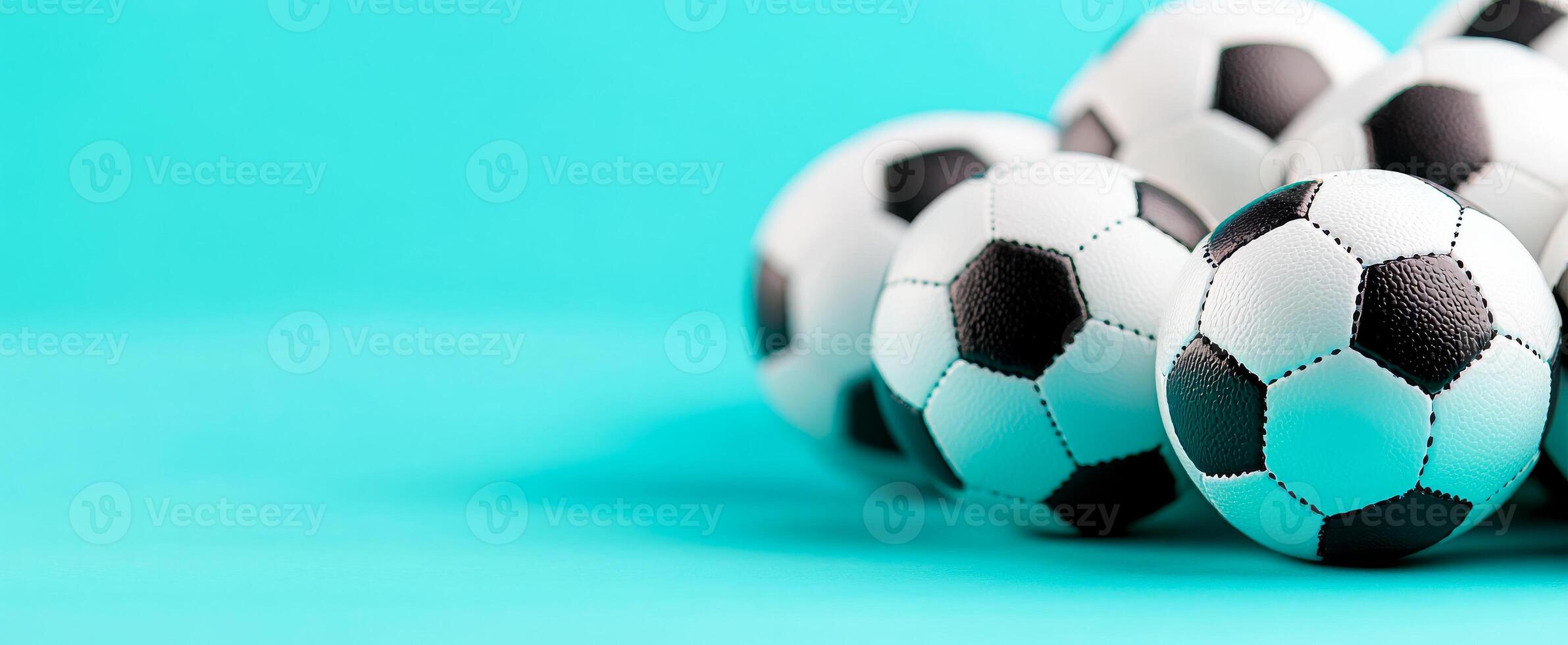 Soccer balls on blue backdrop. Six soccer balls are clustered together on a bright blue surface, showcasing their iconic black and white patterns. photo