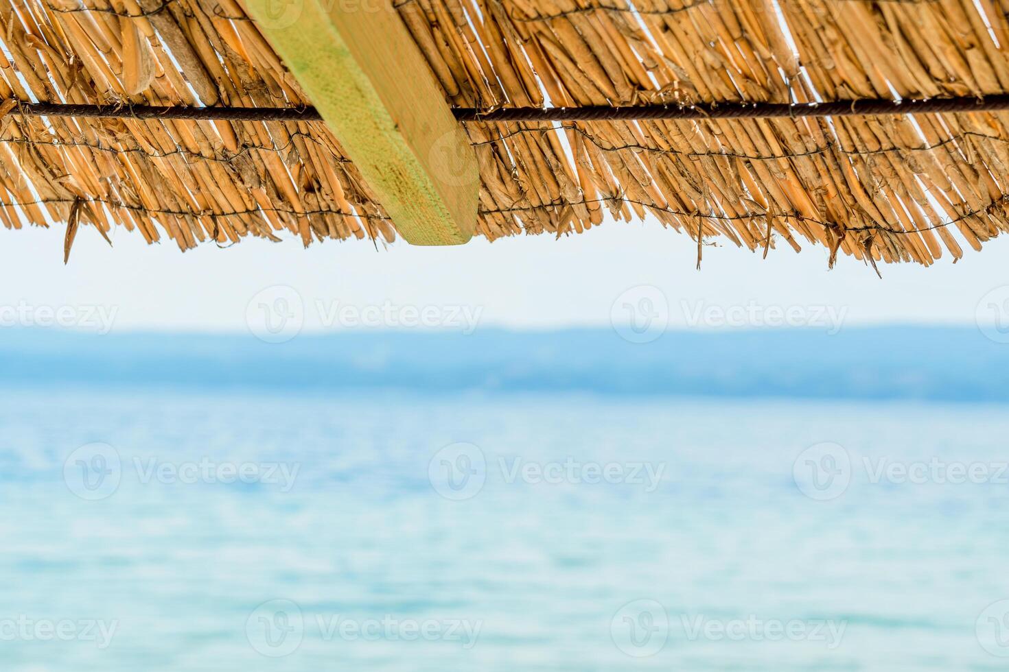 A tranquil and peaceful scene of a vibrant beach umbrella casting a relaxing shade on a sandy shoreline by the sparkling sea, creating a perfect coastal getaway on a sunny day. photo