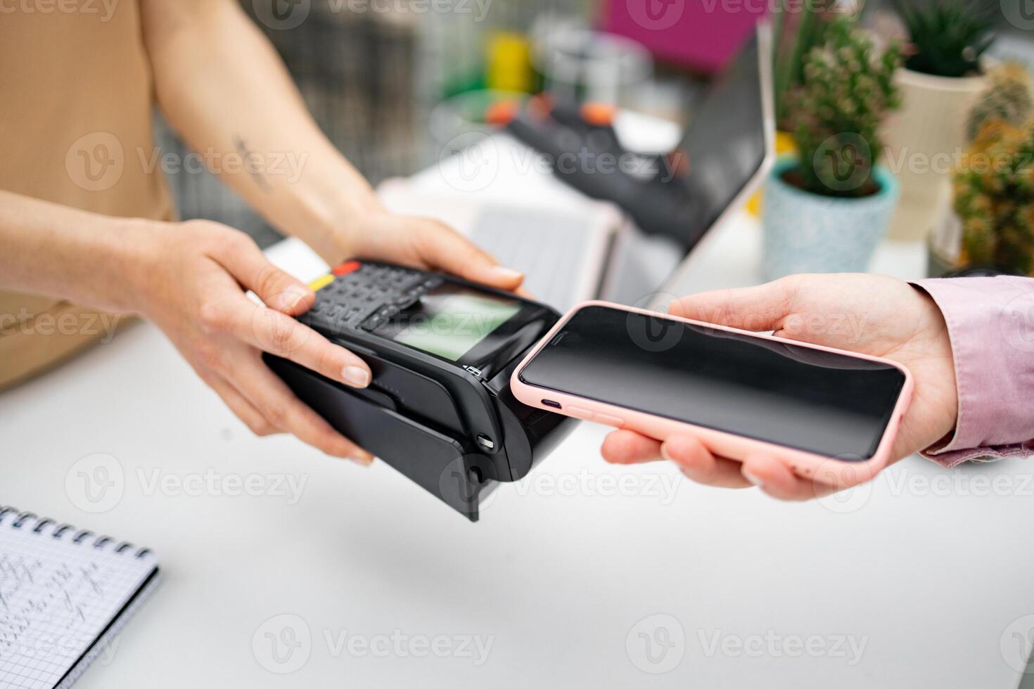 A customer makes a contactless payment at a florist shop using a smartphone device. photo
