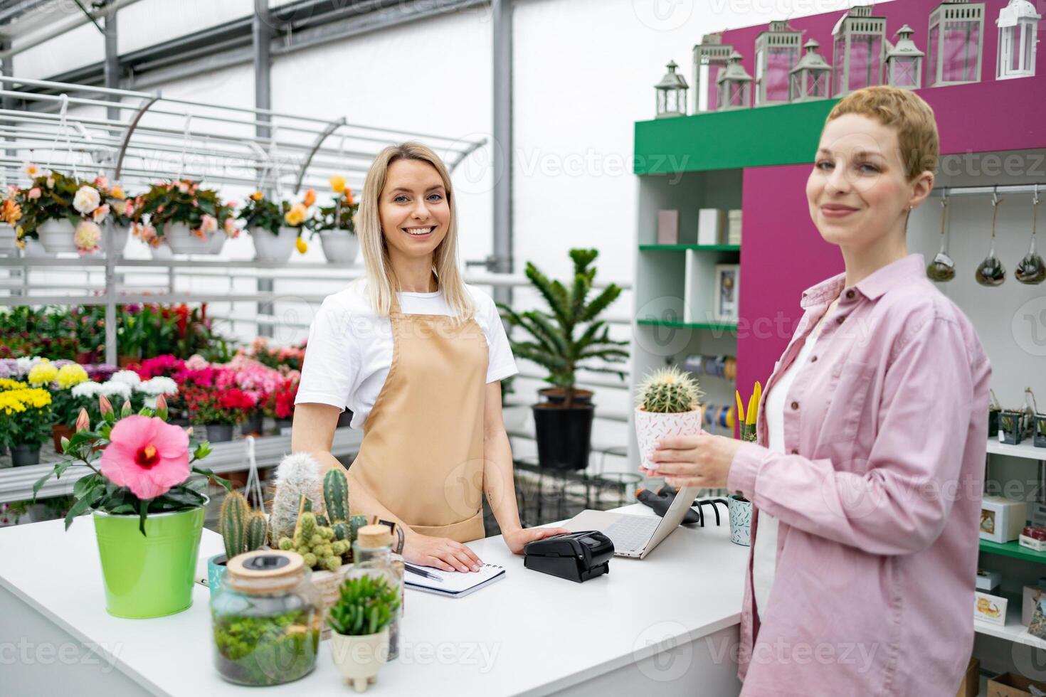 A florist shop scene features a sale transaction involving a smiling woman and a cashier with a cactus. photo