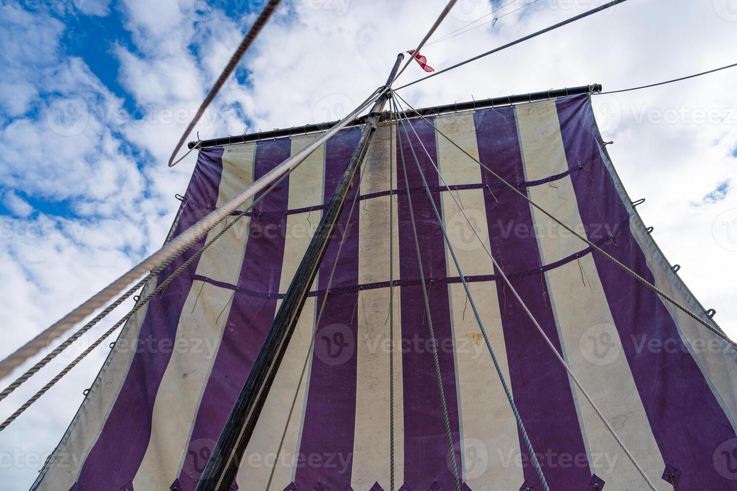 A close-up shot capturing the intricate details of a majestic Viking longship sailing gracefully under clear blue skies, a symbol of ancient maritime adventure and exploration. photo