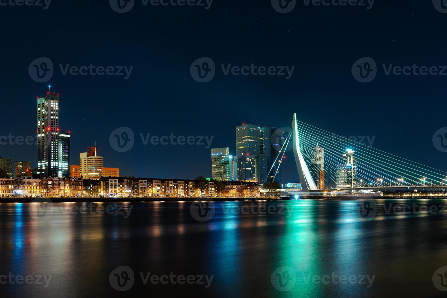 A breathtaking view of Rotterdam's business center at night, showcasing the illuminated skyscrapers and the city's radiant glow against the dark sky, creating a mesmerizing urban landscape. photo