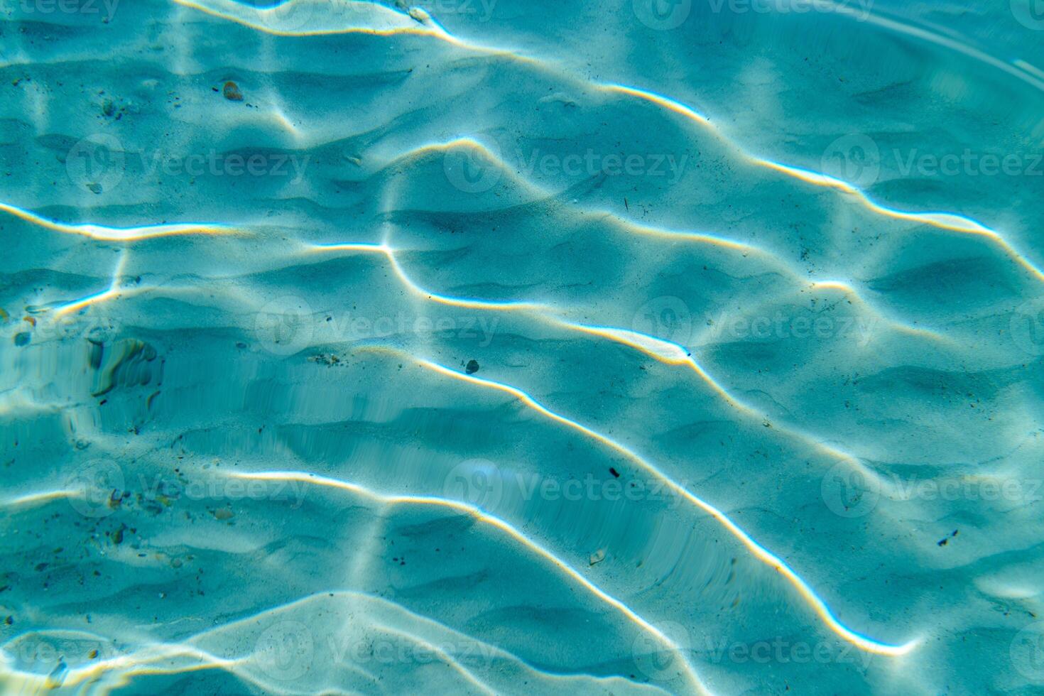 Experience the tranquility of underwater nature with sunlight dancing through clear water, illuminating the sandy seabed. Perfect for themes of travel, relaxation, and serenity. photo