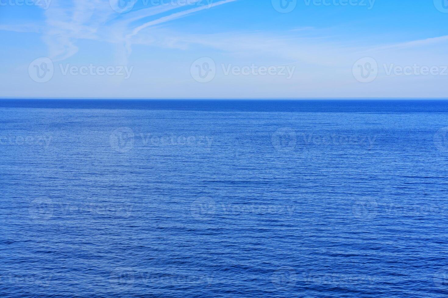 Capture the serenity of a deep blue ocean meeting an endless clear sky, perfect for promotional purposes, product placement, and ad campaigns. photo