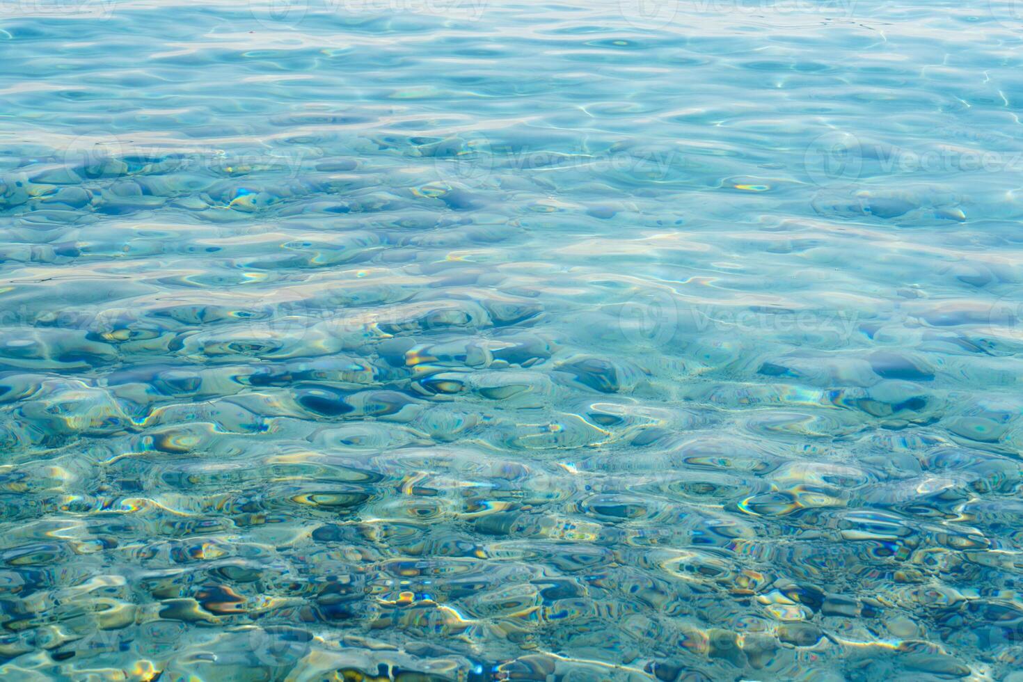 A stunning view of the seabed through crystal-clear, azure water. The underwater pebbles create a serene scene, evoking tranquility and natural beauty, ideal for travel or relaxation. photo