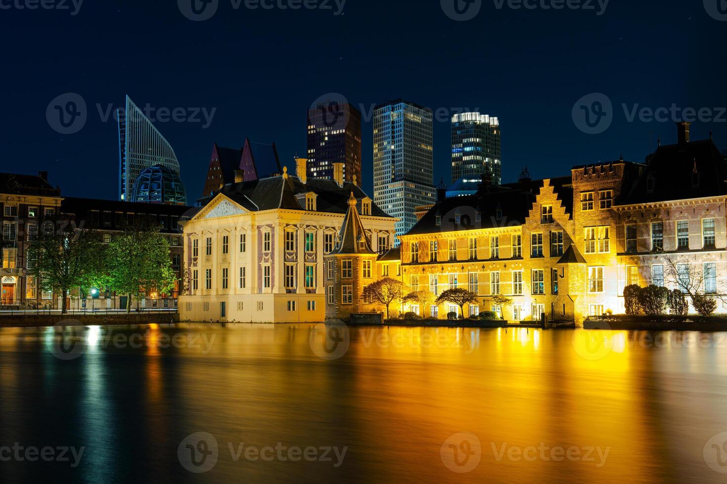 The city of The Hague, Netherlands is captured at nightfall, with the urban landscape sparkling with city lights against the darkening sky, creating a captivating and magical scene. photo