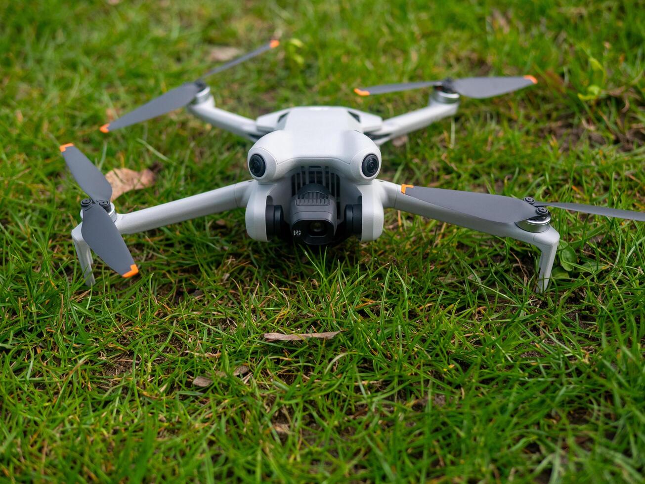 White drone a a flying over a green field photo