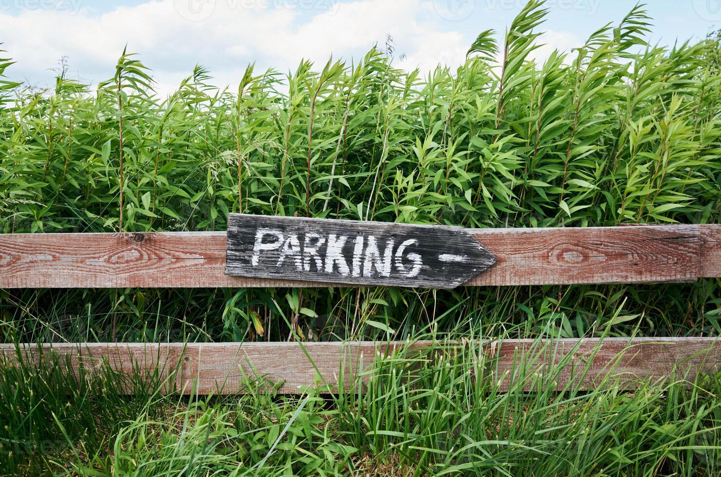 Sign that says parking is on a wooden fence photo