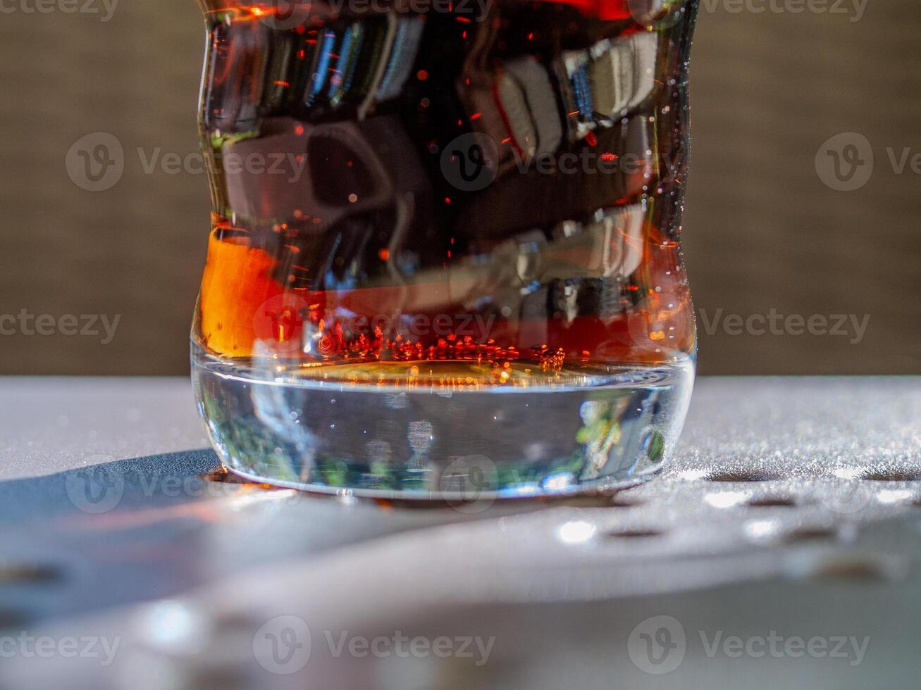 Glass of soda with a swirl pattern on the side photo