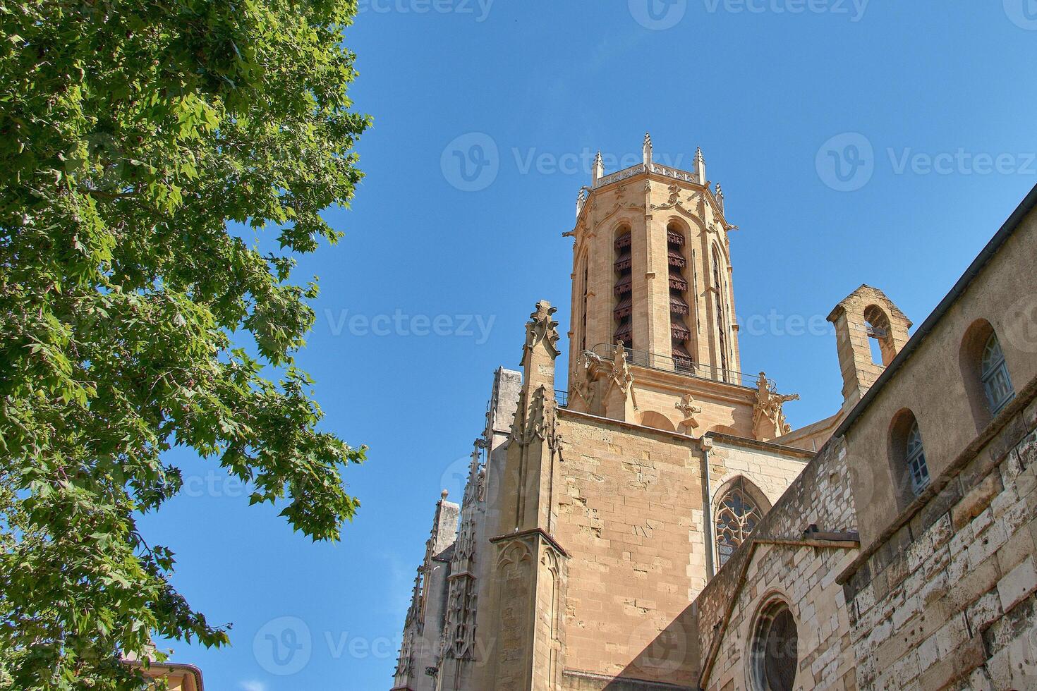 Detail of the clock tower of the Town Hall of Aix en Provence with Renaissance elements against a vibrant blue summer sky photo