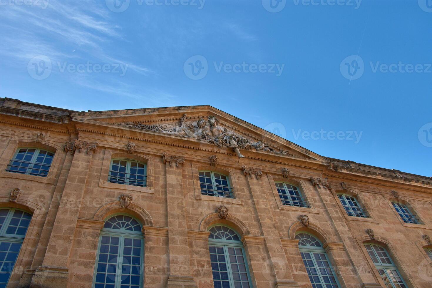 Post office facade in Aix-en-Provence with classical sculptures and architectural details under a clear blue sky photo