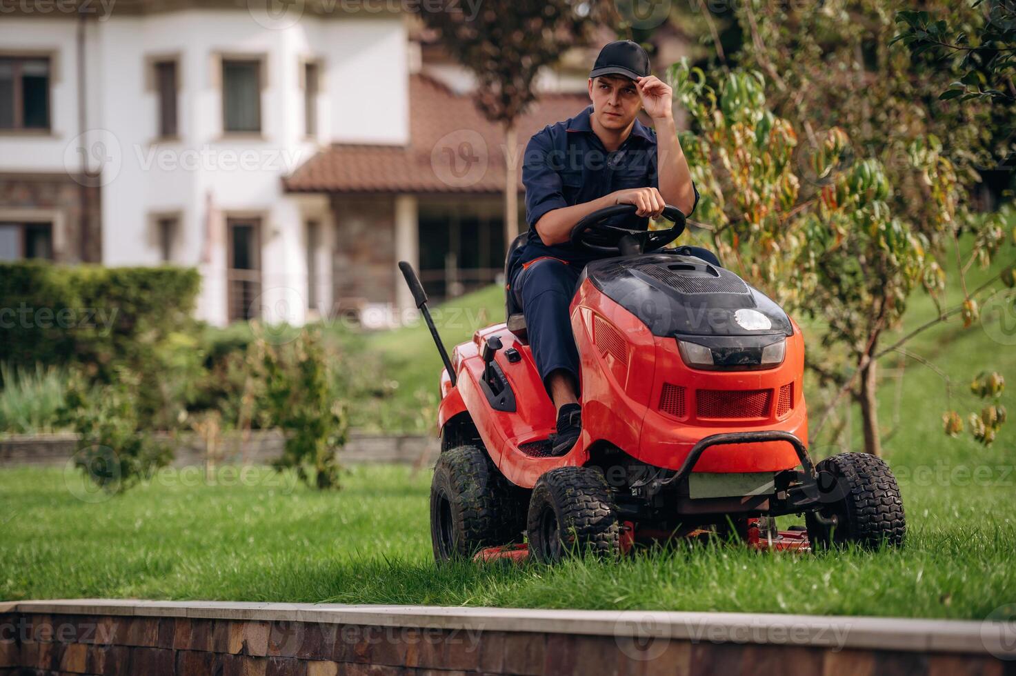Sitting on, the,, lawn mover. Professional gardener is on the lawn photo