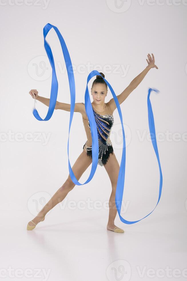 a girl from rhythmic gymnastics in a standing bodysuit, shows an exercise with a ribbon photo