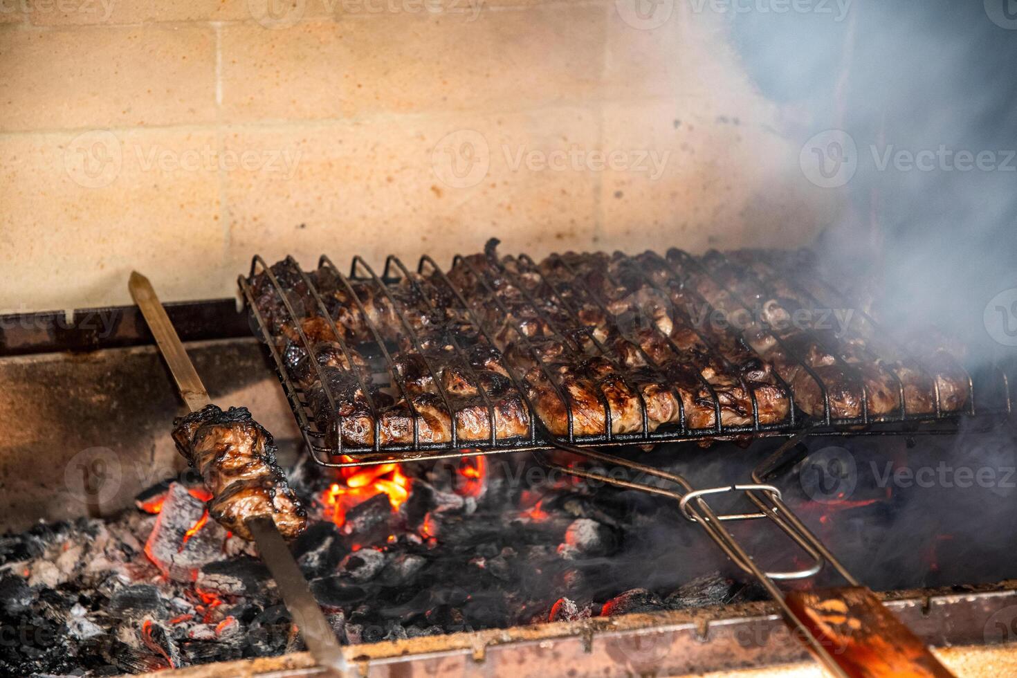 Lot of pieces of meat on skewers in special grill,fried on hot coals that produce aromatic smoke and creating delicious food, which is ideal for summer barbecue party in the fresh air, motion blur photo