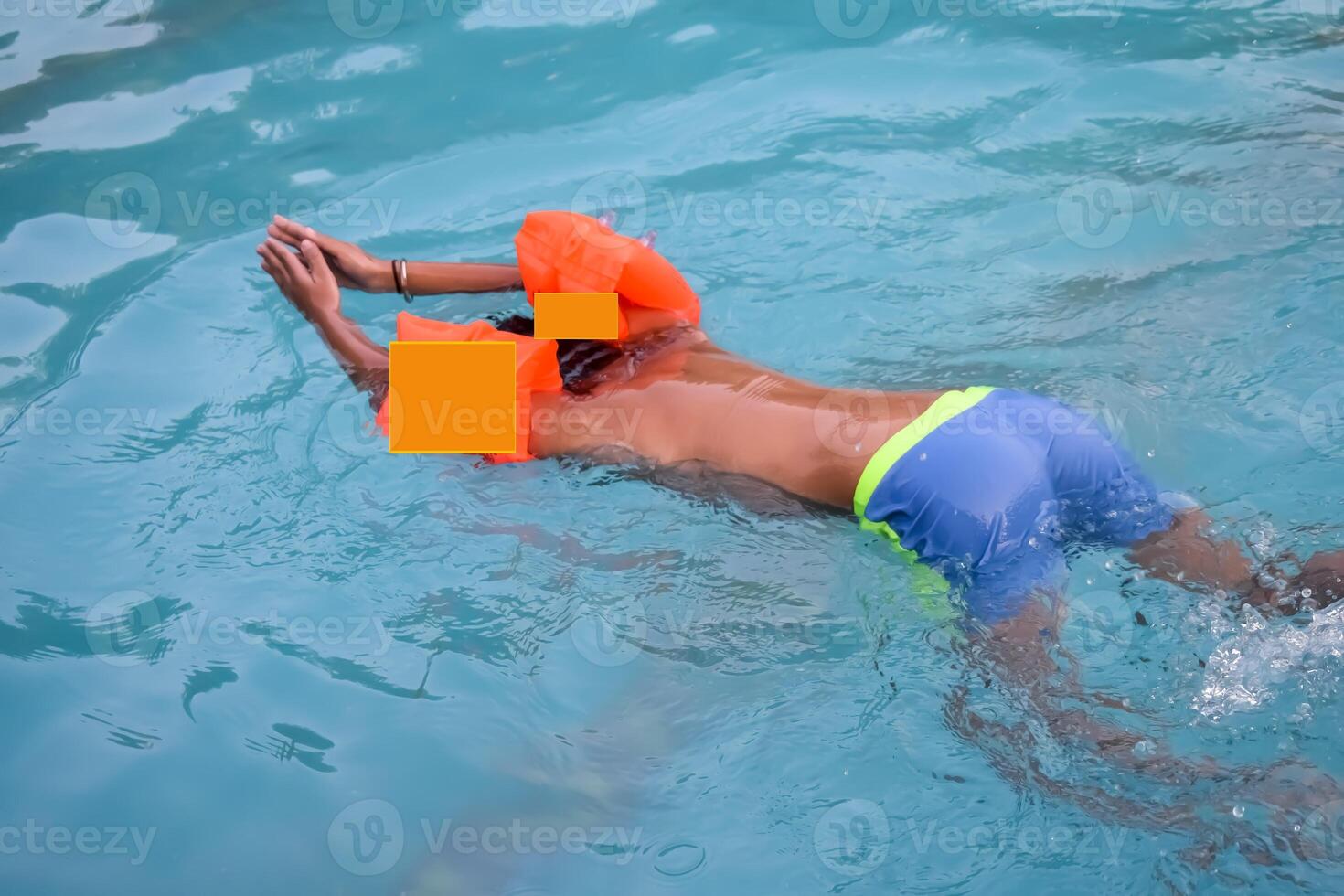 A man in a swimming pool with an orange life vest photo