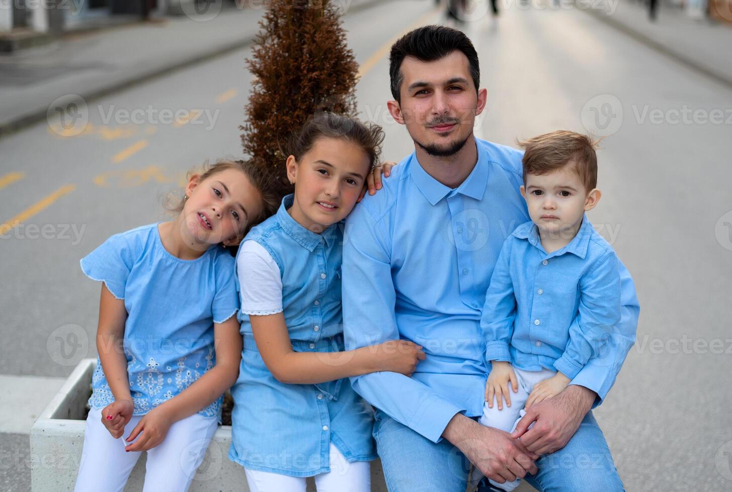Portrait of a happy family, a young father with three children outdoor. Father day. photo