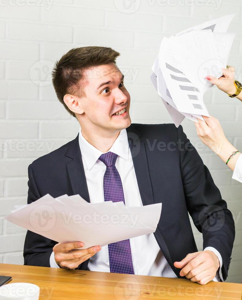 angry business man working at office with documents on his desk photo