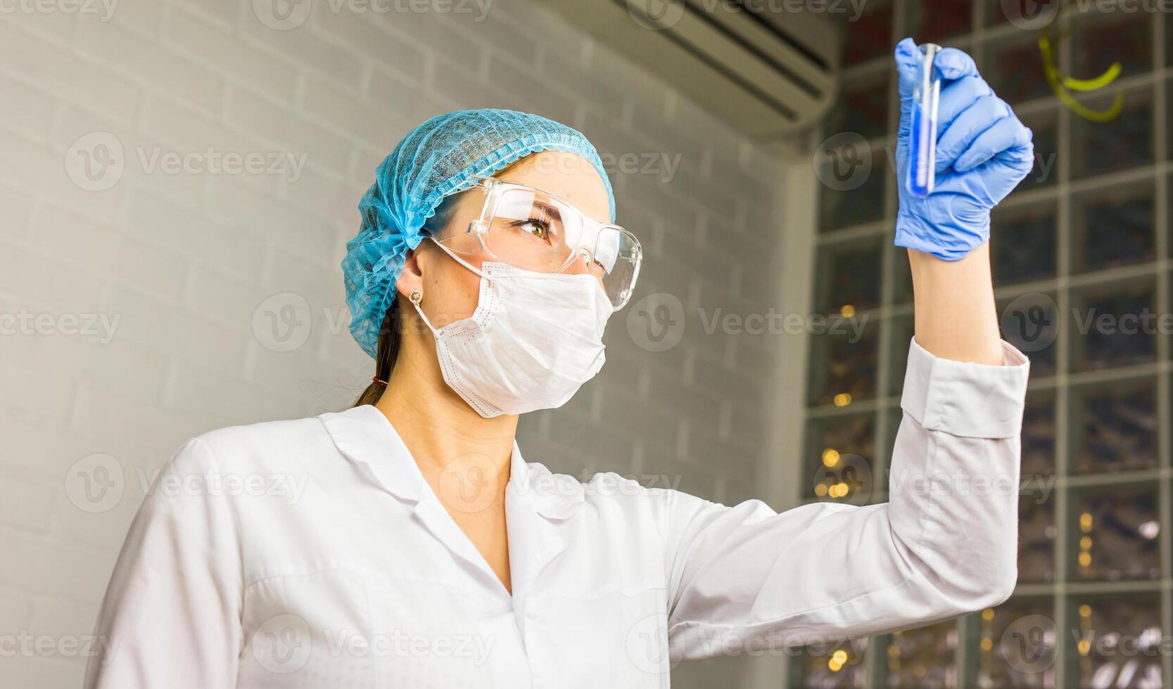 glass tube with blue fluid in nurse hand during medical test photo