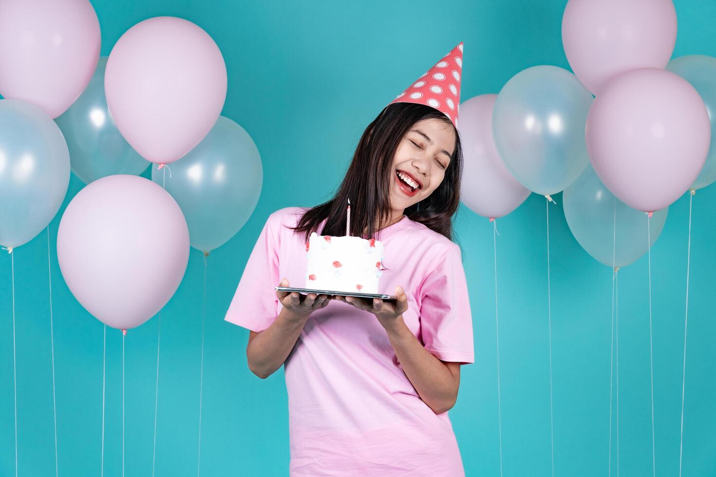 Portrait of Cheerful Young Asian Woman Celebrating Birthday And Dancing With Cake photo