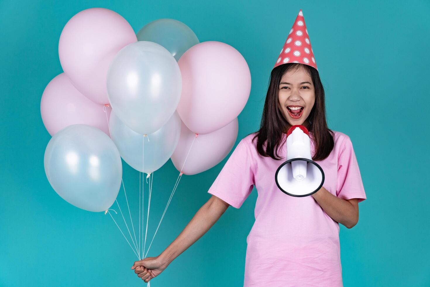 Portrait of Happy Young Asian Woman Celebrating Birthday With Megaphone And Smiling photo